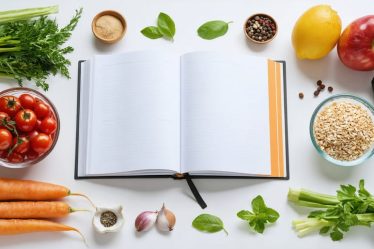 A well-lit kitchen with fresh ingredients like vegetables, fruits, and grains surrounding an open meal planner, symbolizing healthy homemade meal preparation.