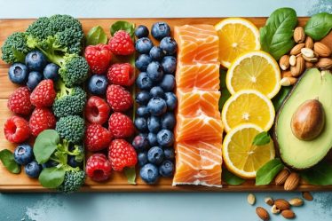 An assortment of colorful skin-nourishing foods including berries, salmon, kale, citrus fruits, and avocado displayed on a wooden board, highlighting their nutritional benefits for healthy, glowing skin.