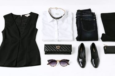 Flat lay of essential fashion items including a black dress, blazer, jeans, white shirt, and statement accessories