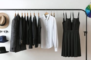 A conceptual image depicting essential wardrobe items like a blazer, white button-down shirt, dark jeans, and a little black dress, symbolizing the creation of a personal and quality wardrobe.