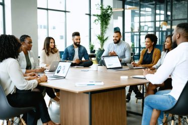 Diverse group of professionals collaborating around a table, embodying modern career success standards like mentorship, work-life balance, and personal development.