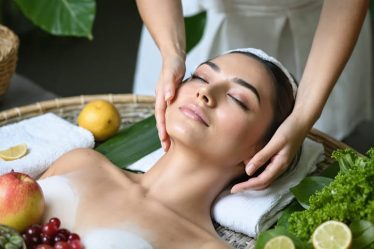 Person in a serene setting performing a holistic skincare ritual with natural ingredients, surrounded by fresh fruits and leafy greens, highlighting the connection between diet and skin health.