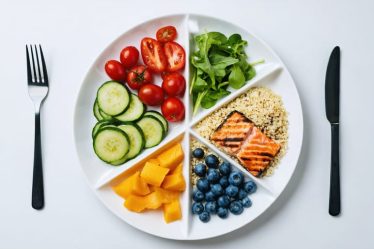 A plate artfully arranged with a variety of colorful vegetables, whole grains, and lean protein, representing a balanced and nutritious meal concept.