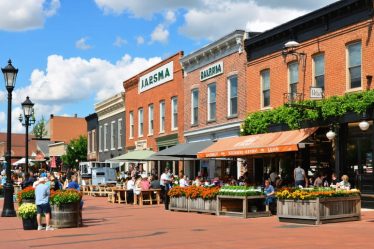 A street view of Pella, Iowa, showcasing Dutch-inspired architecture, bustling cafes, and local food markets, symbolizing the town's diverse culinary scene.