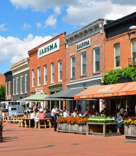 A street view of Pella, Iowa, showcasing Dutch-inspired architecture, bustling cafes, and local food markets, symbolizing the town's diverse culinary scene.