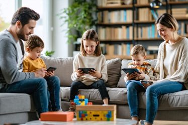 A family gathered in a living room, balancing digital device use while maintaining personal connections, embodying smart digital boundaries.