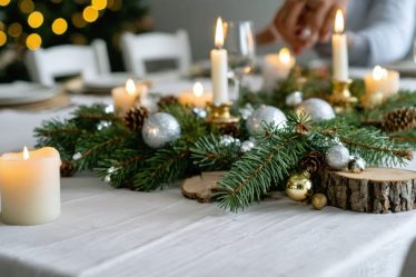 A calming holiday table setup with natural decorations like pine branches, wooden ornaments, and candles, surrounded by people sharing sincere conversations, depicting a mindful holiday gathering.