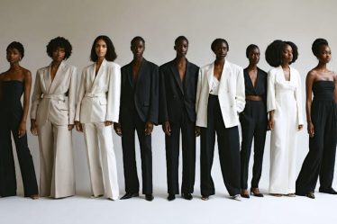 Models of varied body types and gender expressions stand confidently in a studio, dressed in minimalist, gender-neutral outfits including oversized blazers and fluid silhouettes in neutral tones, representing the evolution of fashion beyond traditional gender norms.