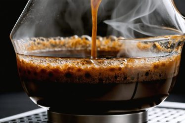 Coffee being brewed with steam rising, illustrating the chemical reactions and extraction of compounds from coffee grounds.